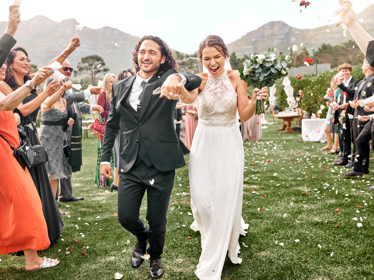 bride and groom walking back down the aisle while guests throw flower petals