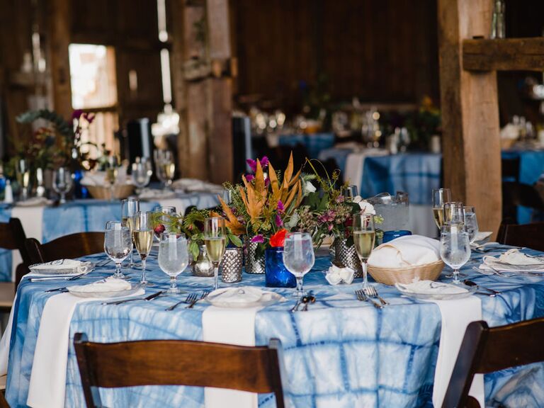 Blue and white tie-dye tablecloths at rustic barn wedding reception
