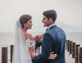 A couple look lovingly into each other's eyes by the water