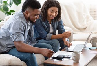 Engaged couple planning and budgeting for honeymoon.