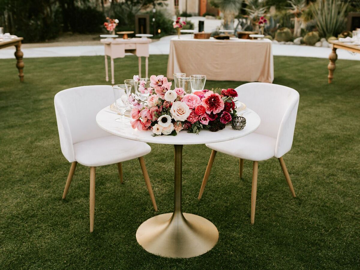 wedding table with two chairs and pink floral centerpiece