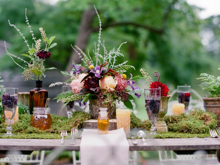 Outdoor wedding reception with moss table runner