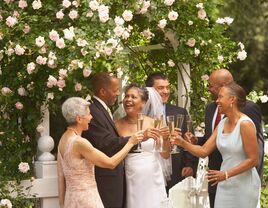 Couple toasting champagne flutes with guests