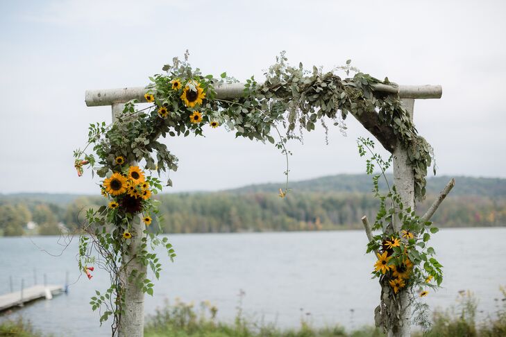 The couple exchanged vows in an outdoor ceremony under a sunflower-covered arch.