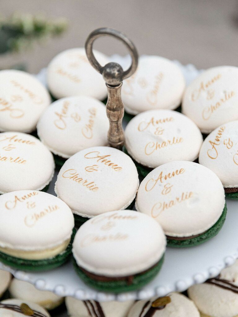 white macarons decorated with couple name written in gold calligraphy lettering