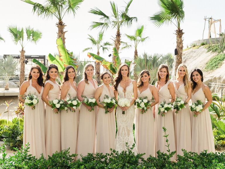 Bridesmaids wear nude colored gowns for a beach wedding. 