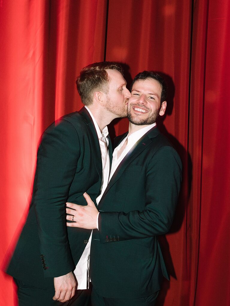 Newlyweds in front of red drapes