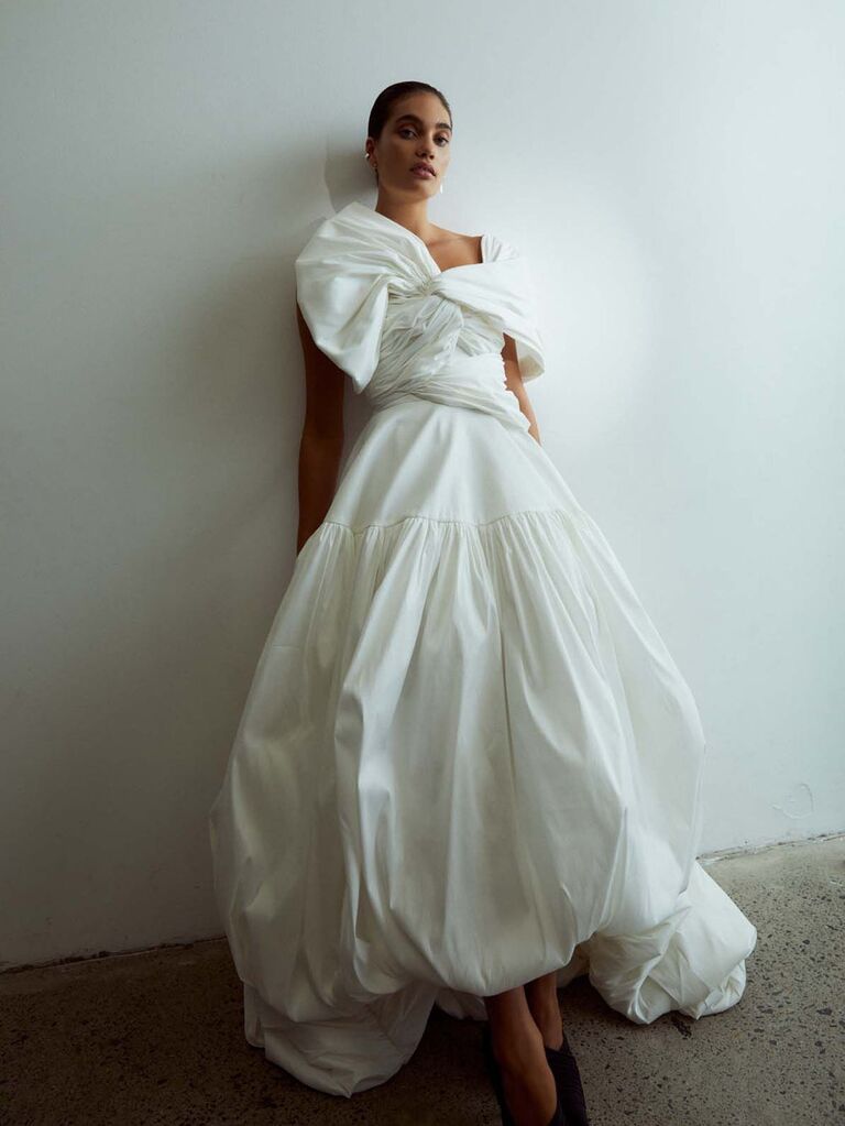 Model wears a puffed white wedding gown. 