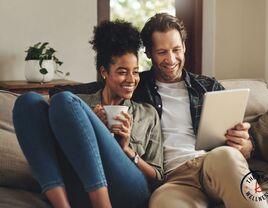 Couple smiling together on sofa using conversation starters 