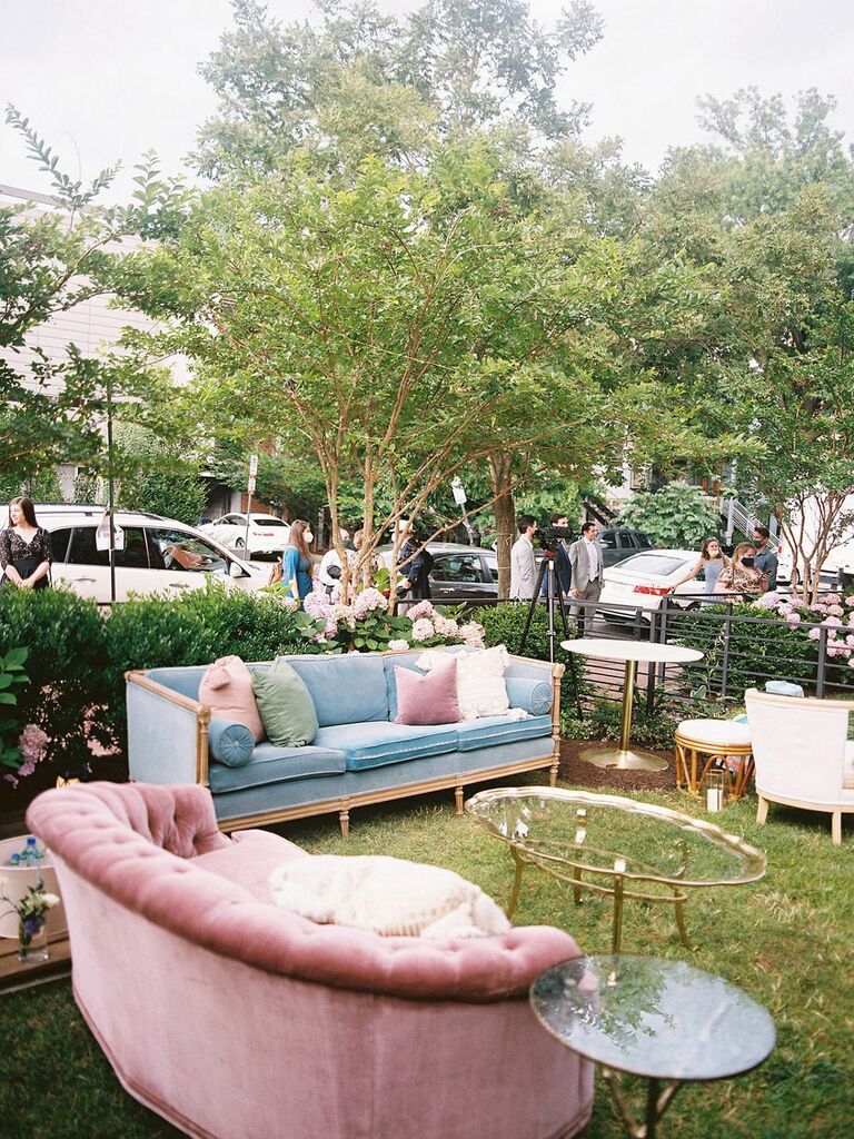 Art deco lounge seating area at wedding reception with velvet pink and blue couches