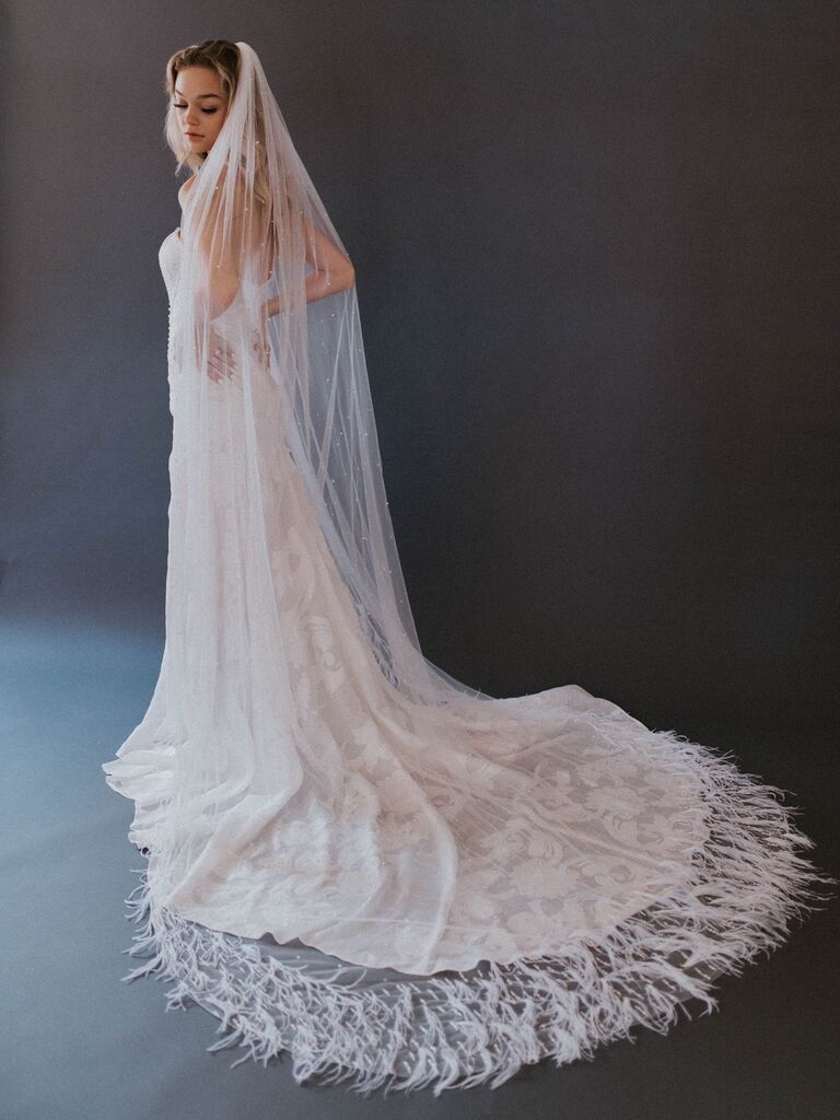 Model wears a cathedral-length sheer veil with pearl accents. 