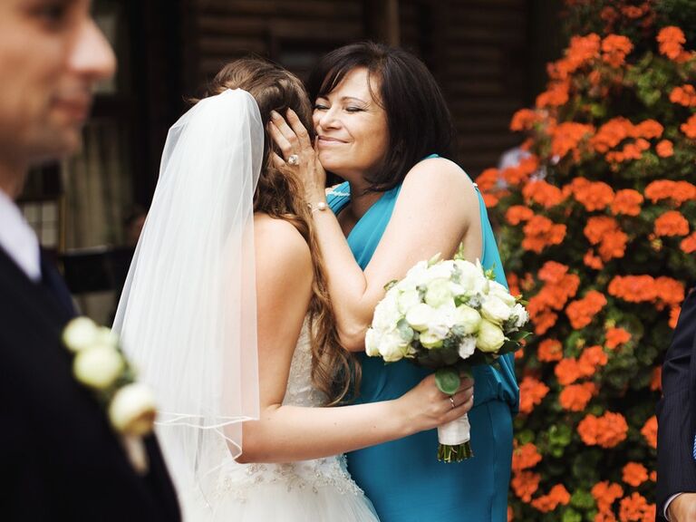 A bride and her mother sharing a hug on the wedding day