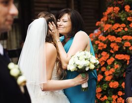 A bride and her mother sharing a hug on the wedding day