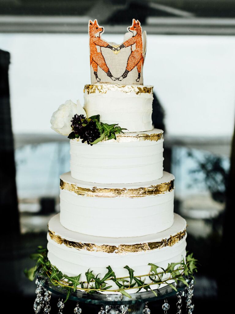 Rustic wedding cake topper with foxes holding hands at barn wedding