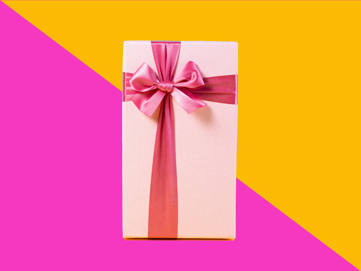 Wrapped bridal shower gift or wedding gift with pink bow on a split colored background