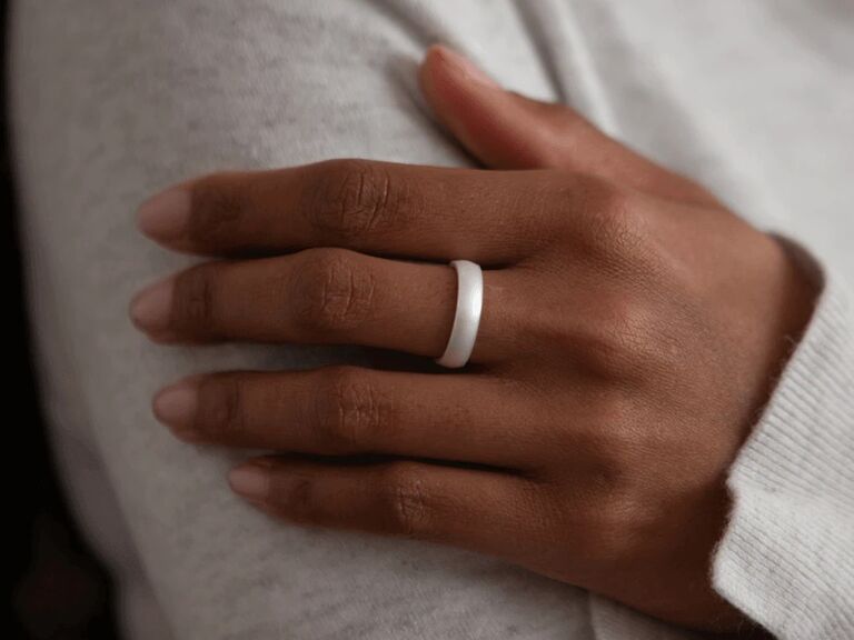 Hand wearing minimalist shiny white silicone ring
