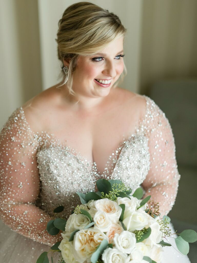 bride wearing beaded ball gown with illusion sleeves and portrait neckline