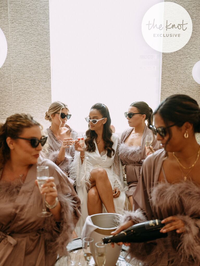 Erika Priscilla and her bridesmaids sipping champagne 