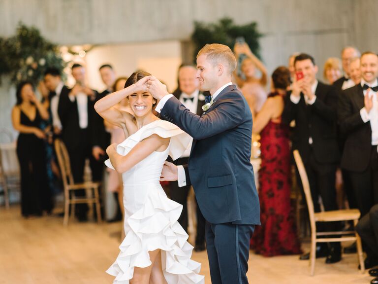 Husband twirling his wife during their first dance