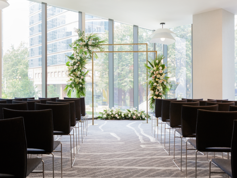 Sleek indoor ceremony space beside floor to ceiling windows