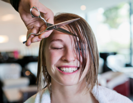 Hairdresser cutting bangs on woman