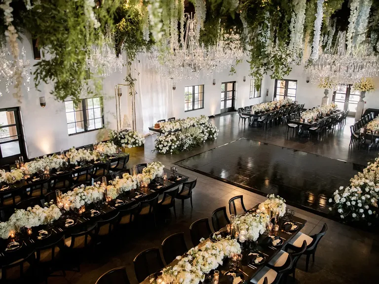 Indoor wedding reception with black dance floor and hanging floral decor at Viansa Winery in Sonoma, California 