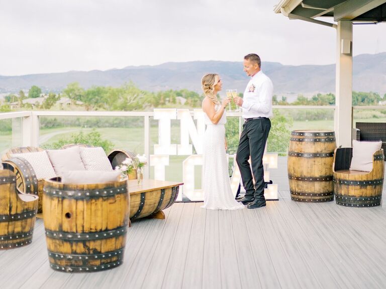 Couple toasting their champagne glasses on the venue's loft patio