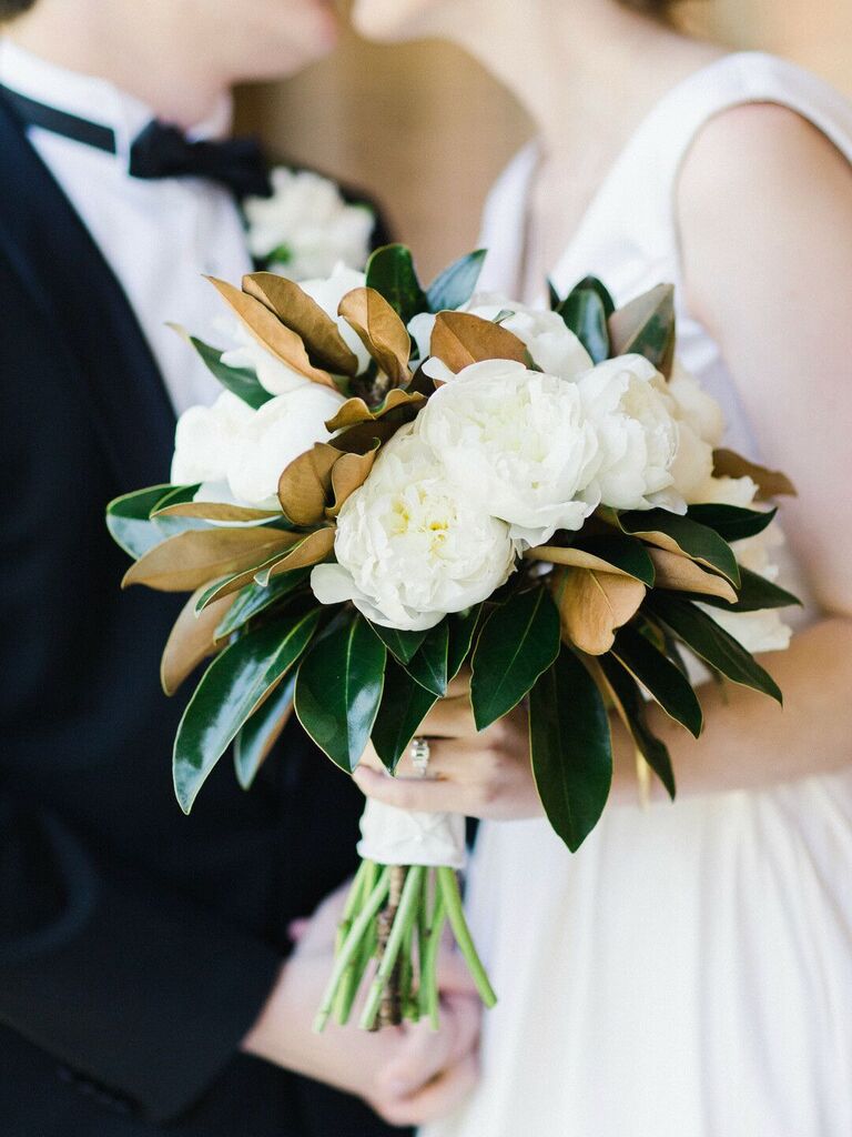 timeless winter wedding bouquet with white peonies and magnolia leaves