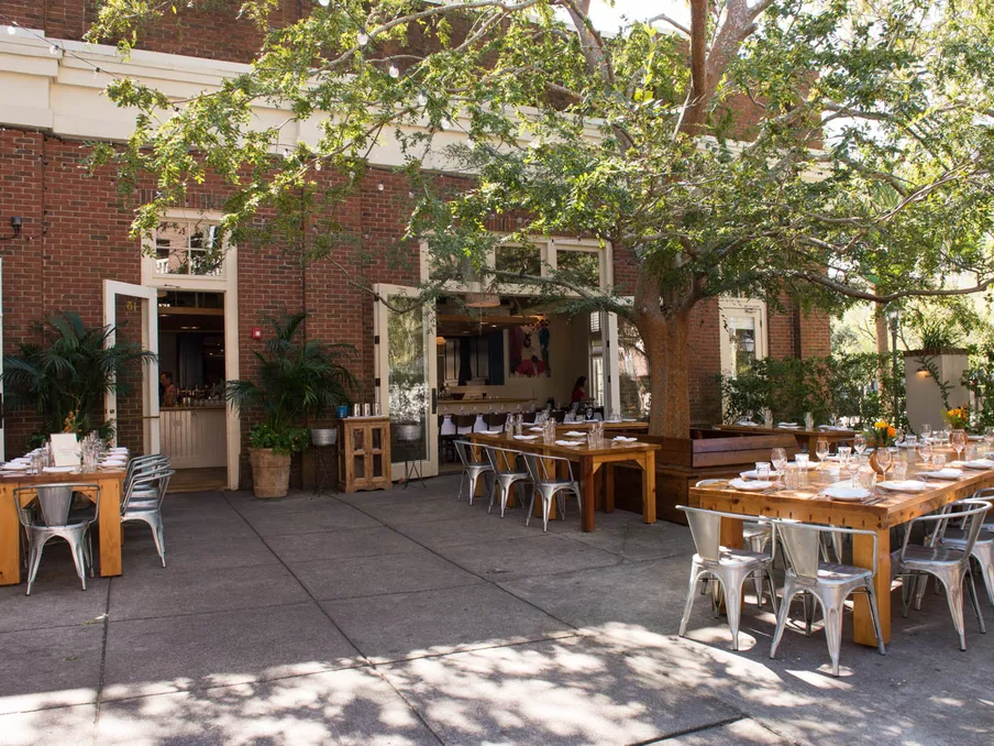 Dappled sunlight peeks through the trees to fall on this gorgeous event space at Le Farfalle.