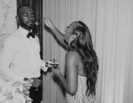 Black-and-White Candid Photo of Bride Feeding Groom Cake During Cutting, Funny Expressions