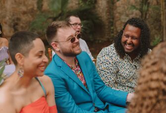 Wedding guests sitting down for the ceremony and laughing together