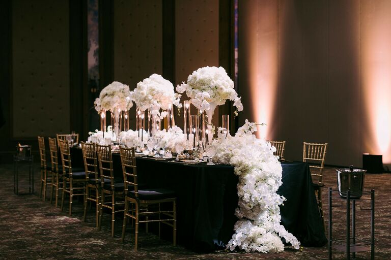 Reception table with floral runner and tall floral centerpieces