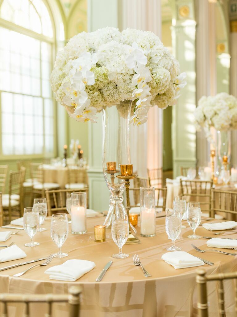classic tall wedding centerpiece with white hydrangeas and orchids in clear glass trumpet vase