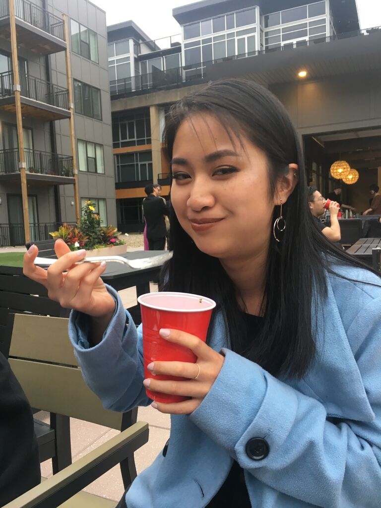 Hannah after a long day of doing makeup for the same wedding, oblivious to Ziyue's advances. Seen here shoving food into her face. (Cheese cubes are in the cup.) 