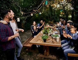 Couple and friends enjoying engagement party in backyard