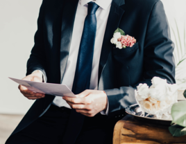 Groom reading letter from parents on wedding day