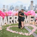 Couple hugging in front of "Marry me" sign