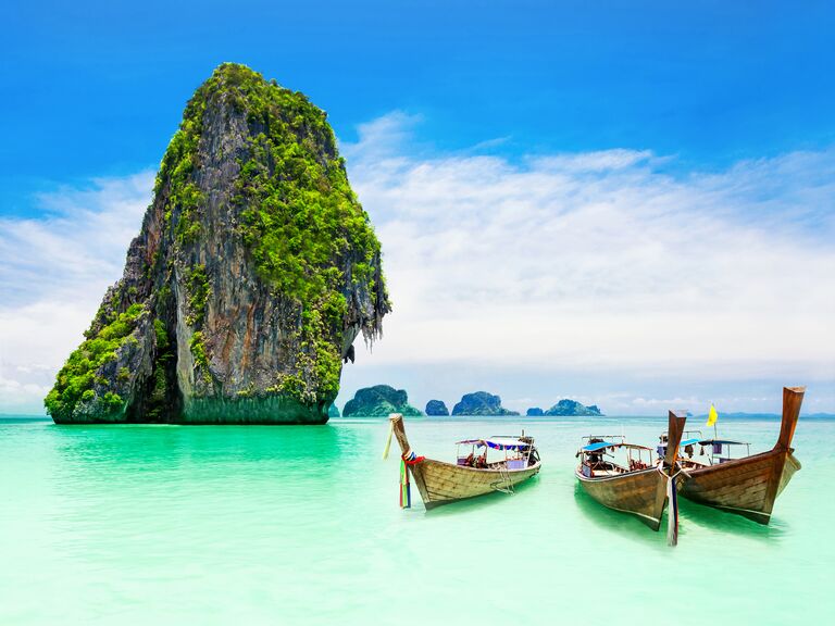 Scenic beach in Thailand with boats and stunning sea stack