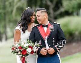 groom in military uniform posing with bride