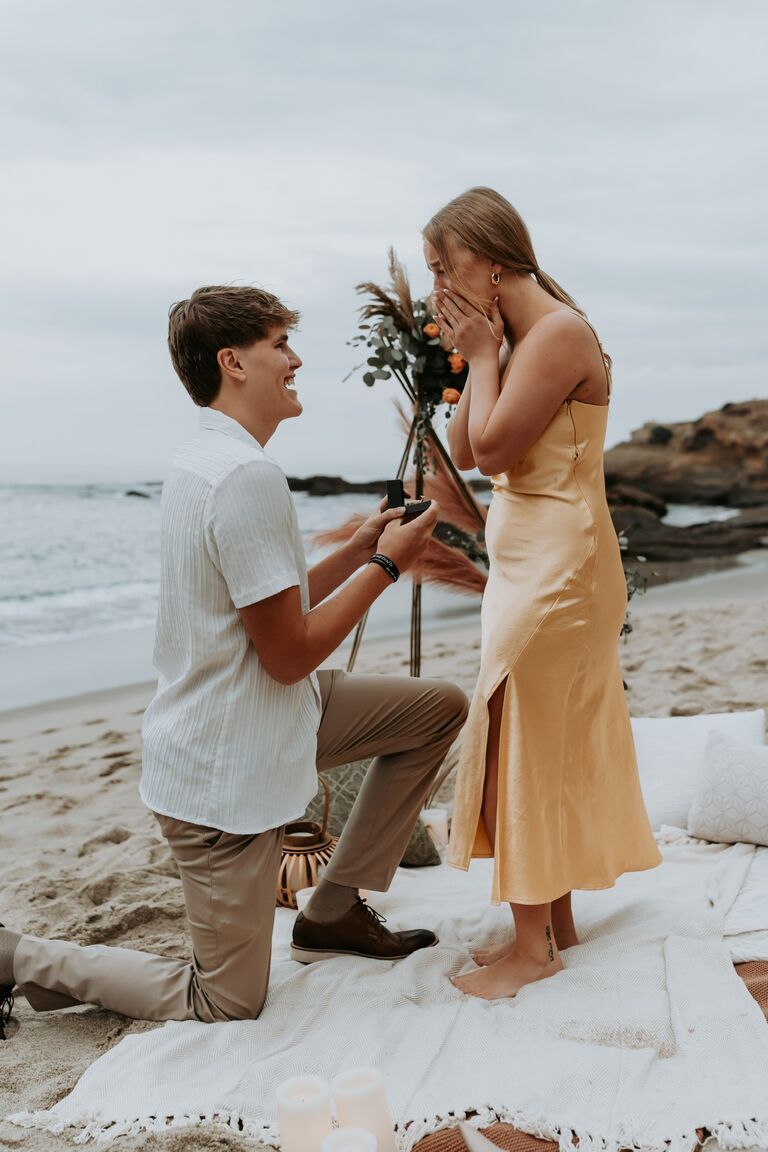 Our ENGAGEMENT! 

-- Nate surprised Hannah by telling her they were going to a birthday dinner his parents reserved for the two of them in Laguna Beach. Nate's parents coincidentally called and apologetically said they provided the wrong reservation time and that there would be time to hang out and maybe go to the beach. 

-- Nate suggested they go to Treasure Island, somewhere Hannah had suggested before and happened to be nearby, to which Hannah stated no because she was wearing a dress and heels (she was confusing the location with Thousand Steps because she has never been one for geography). Without her figuring out any of the plan, Nate walked Hannah along a cliffside in Laguna Beach until they reached the stairs where he suggested they go down to the sand. Hannah was so caught off guard by the proposal setup that she just kept repeating "Is this for me??". Nate asked Hannah to be his wife, she replied with an absolute YES, and they took in the moment just the two of them. After a minute or so, Nate pulled off another surprise and turned Hannah to face their families that watched the entire proposal in secret from the cliff. Of course, Hannah cried, and they now have the sweetest memory the best day of their lives so far. 

-- We cannot wait to get married and become one, and we are so excited to have you there to celebrate our love! Kleppe 2024!!