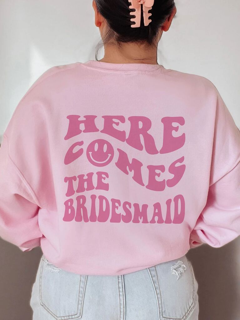 Y2K pink bridesmaid sweatshirt with Here Come The Bridesmaid smiley face graphic