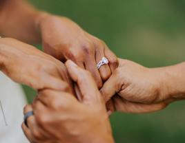 Couple holding hands with engagement ring on