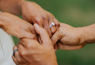 Couple holding hands with engagement ring on