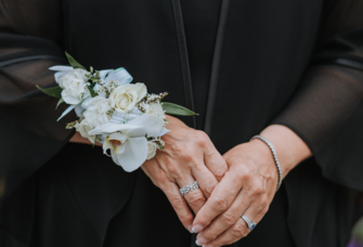 Close-up of mother-in-law's hands with blue floral corsage 
