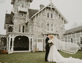 Couple kissing for a portrait outside the stone wedding venue