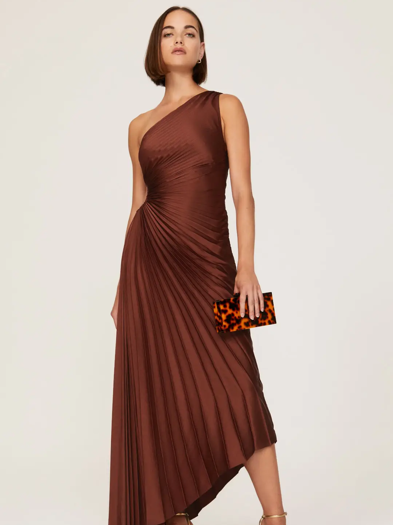 A model wears this amazing one-shoulder sleeveless gown with an asymmetrical hem.