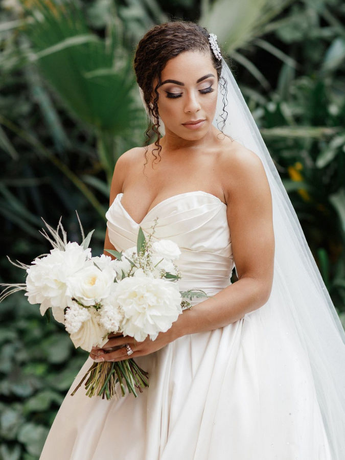 Bride with updo and veil holding white bouquet