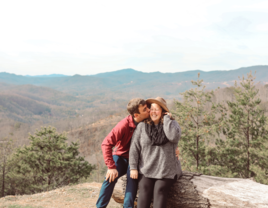 Man kissing fiancée on cheek after proposal in Tennessee mountains