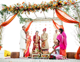 Bride and groom with family at altar during Indian wedding planned by Glitzzy Events LLC in Austin, Texas