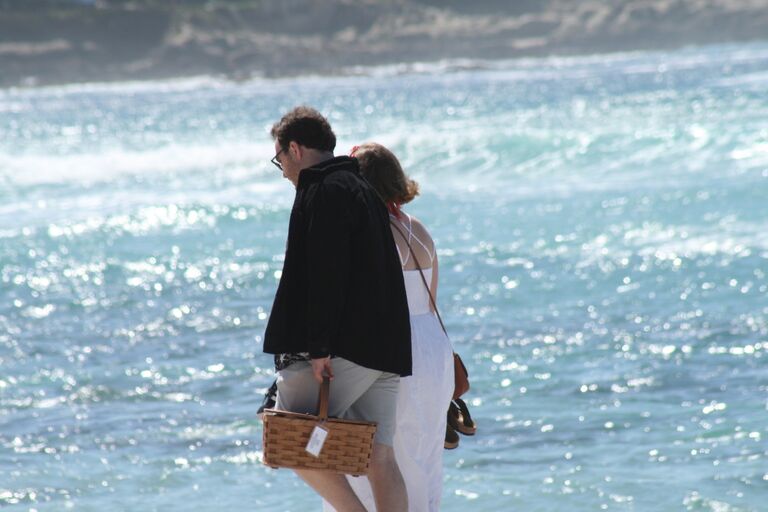 In March, Christopher whisked Ellie away to the charming Northern California beach town of Carmel-by-the-Sea. They stayed in a quaint inn that delivered breakfast in a picnic basket each morning. They basked in the perfect spring weather, savored fresh, locally-made donuts, and enjoyed delicious lattes. Christopher had arranged a delightful afternoon picnic on the beach, where Ellie just so happened to be wearing white.